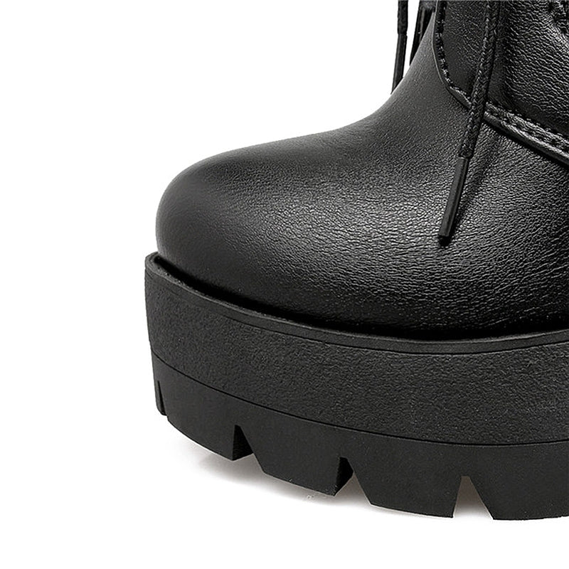 Close-up of black gothic lacing platform boot featuring a high square heel and textured sole.