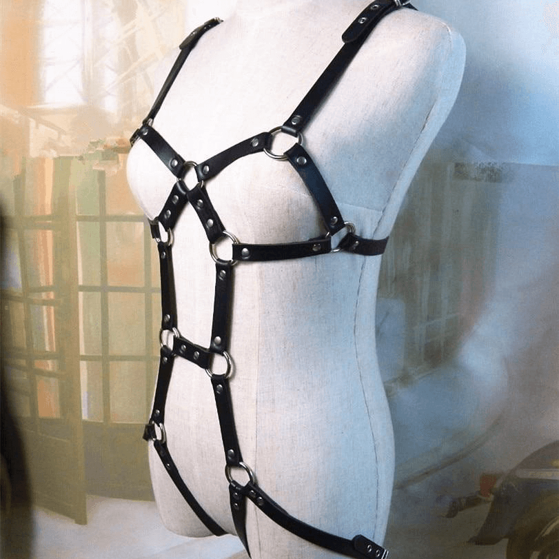 Black leather body harness on mannequin, featuring gothic design with metal elements, perfect for cosplay or fashion statements.