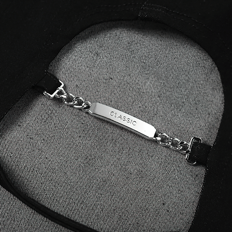 Close-up of a classic silver chain detail on a black fabric garment showing stylish elegance.