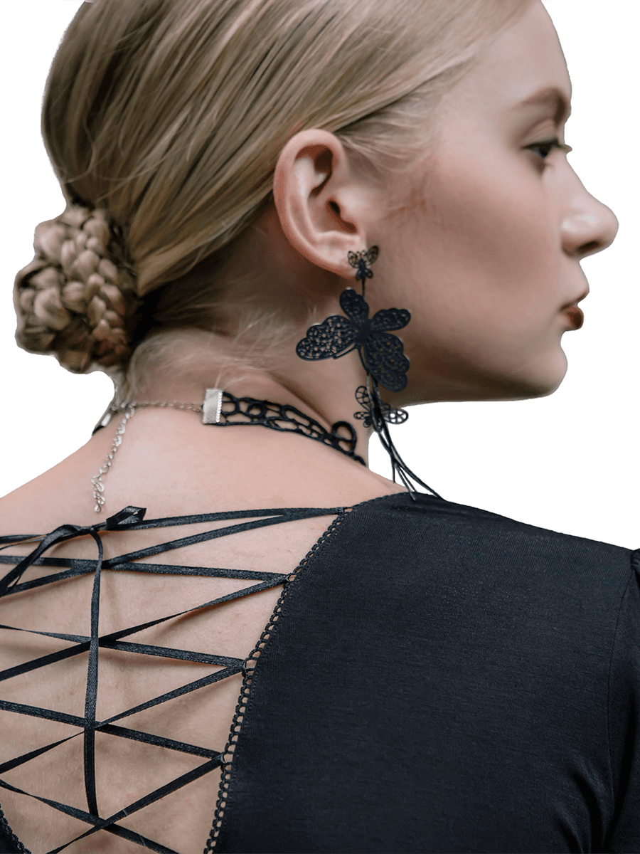 Elegant woman showcasing black lace necklace and butterfly earrings, highlighting gothic fashion style.