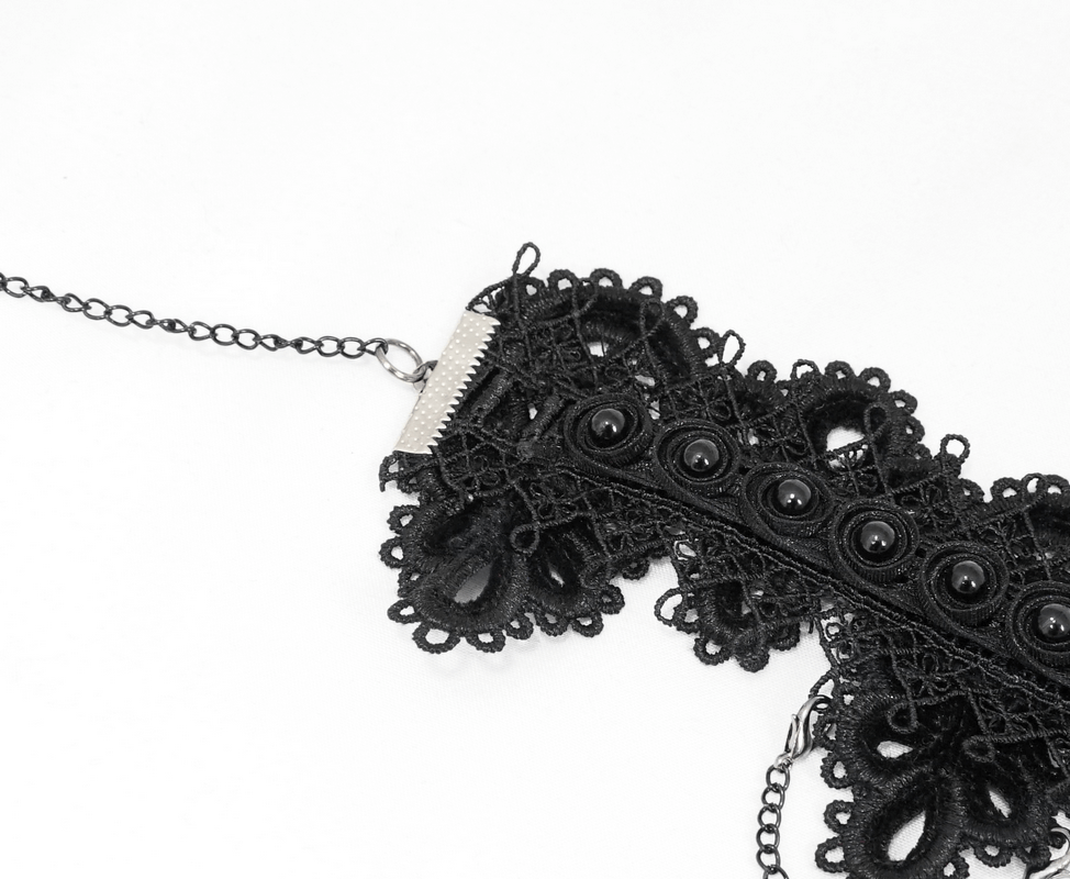 Close-up of women's black lace necklace with buttons, perfect for elegant gothic fashion.