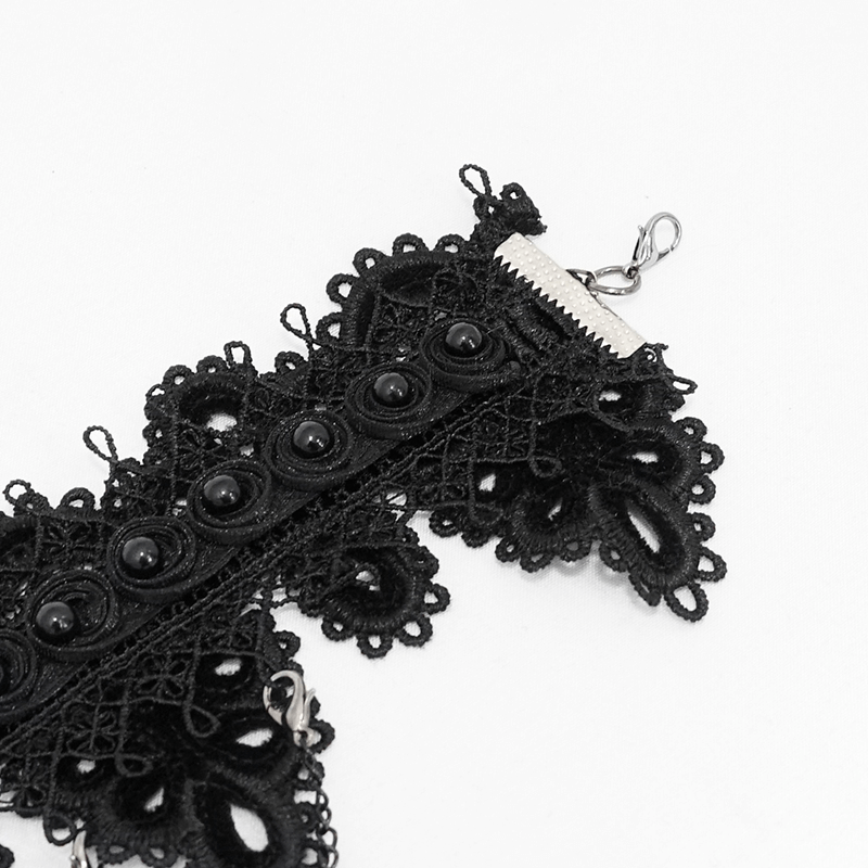 Close-up of a women's black lace necklace with intricate detailing and shiny black beads, showcasing gothic elegance.