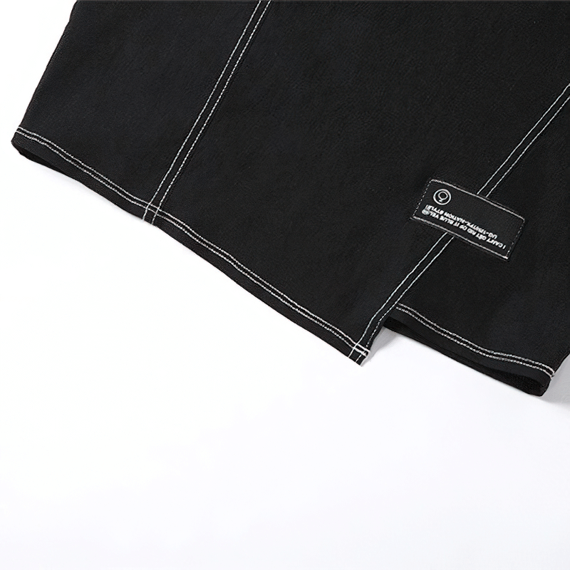 Close-up of a stylish black tube dress with white stitching and a unique label.