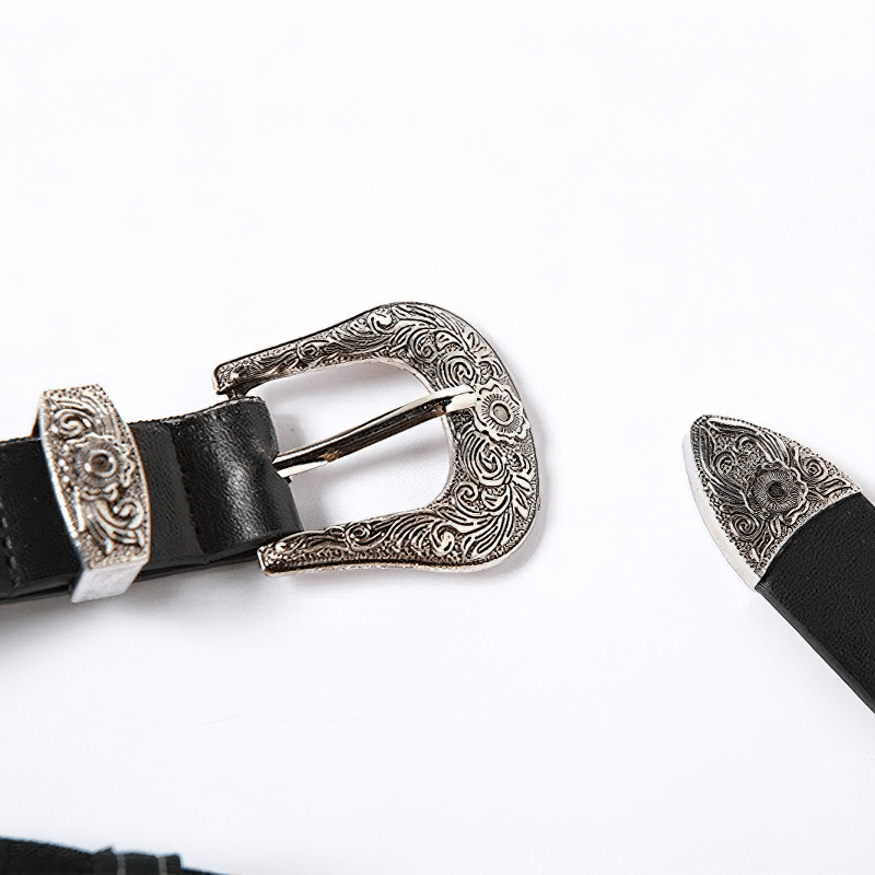 Close-up of a decorative silver buckle on a black belt, showcasing intricate design details and a stylish finish.