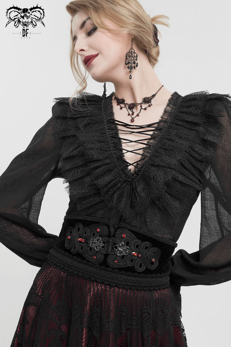 Stylish woman wearing a gothic black lace shirt, accessorized with a vintage black beaded belt and elegant earrings.