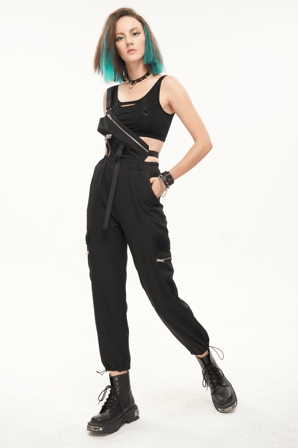 Stylish woman modeling women's punk asymmetrical suspender pants with skull rivets and zippers.