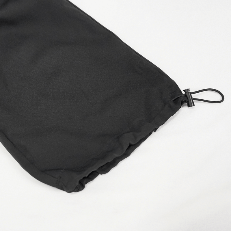 Close-up of the drawstring feature on black women's punk suspender pants with skull rivets.