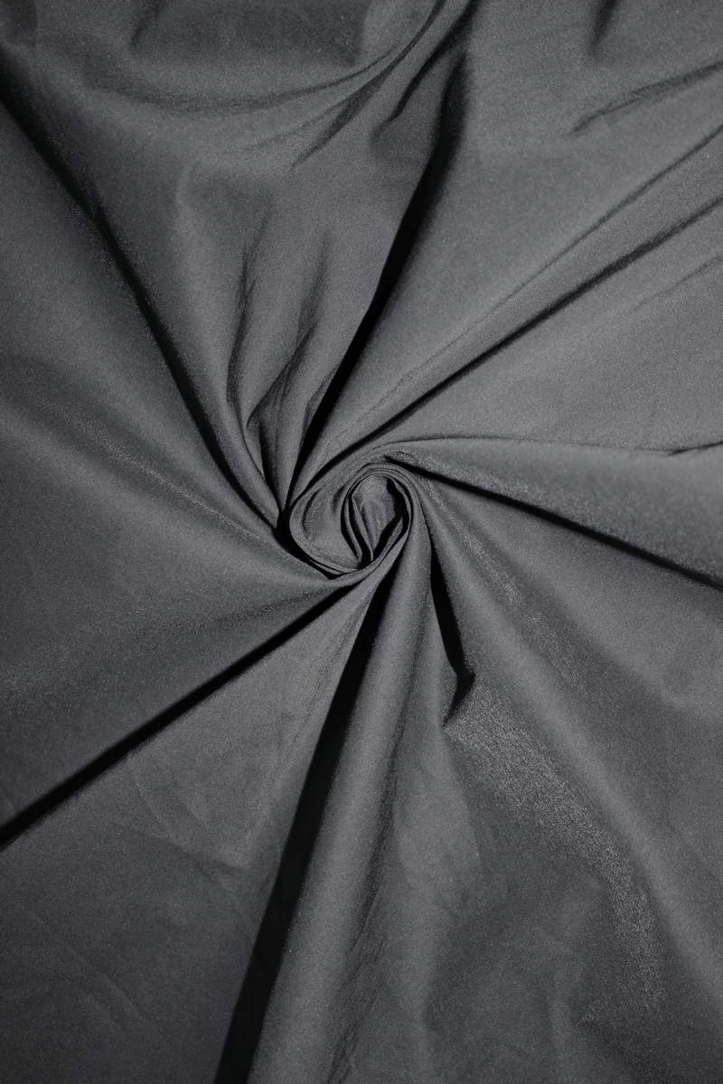 Close-up of black fabric showcasing a smooth, textured surface ideal for gothic-style clothing designs.