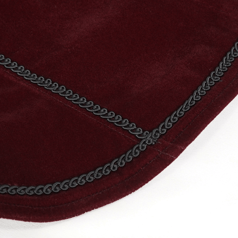 Close-up of wine red velvet fabric with decorative black trim, highlighting gothic style elements.