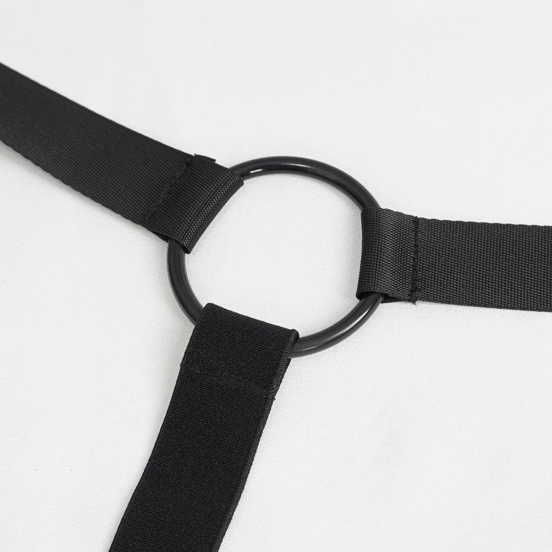 Close-up of a black buckle strap harness with a circular metal ring, ideal for grunge-style outfits.