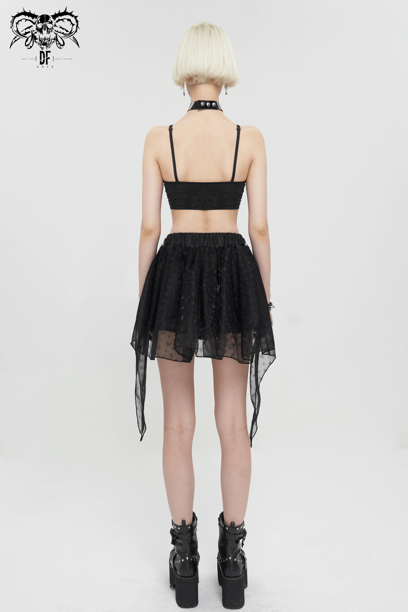 Back view of a woman wearing a black irregular layered mesh skirt and matching top in grunge style with chunky boots.