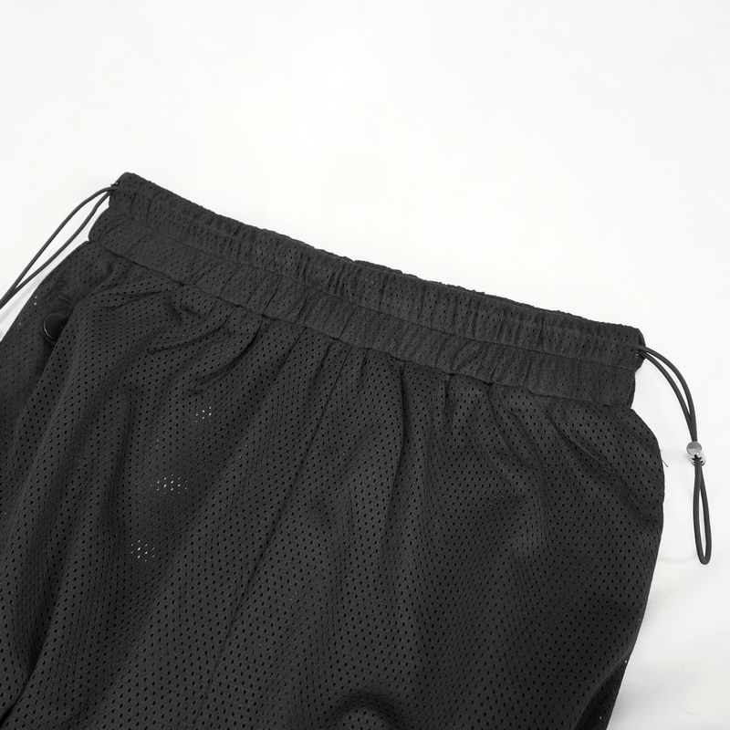 Close-up of black women's mesh jogger pants featuring a drawstring waistband for comfort and style.
