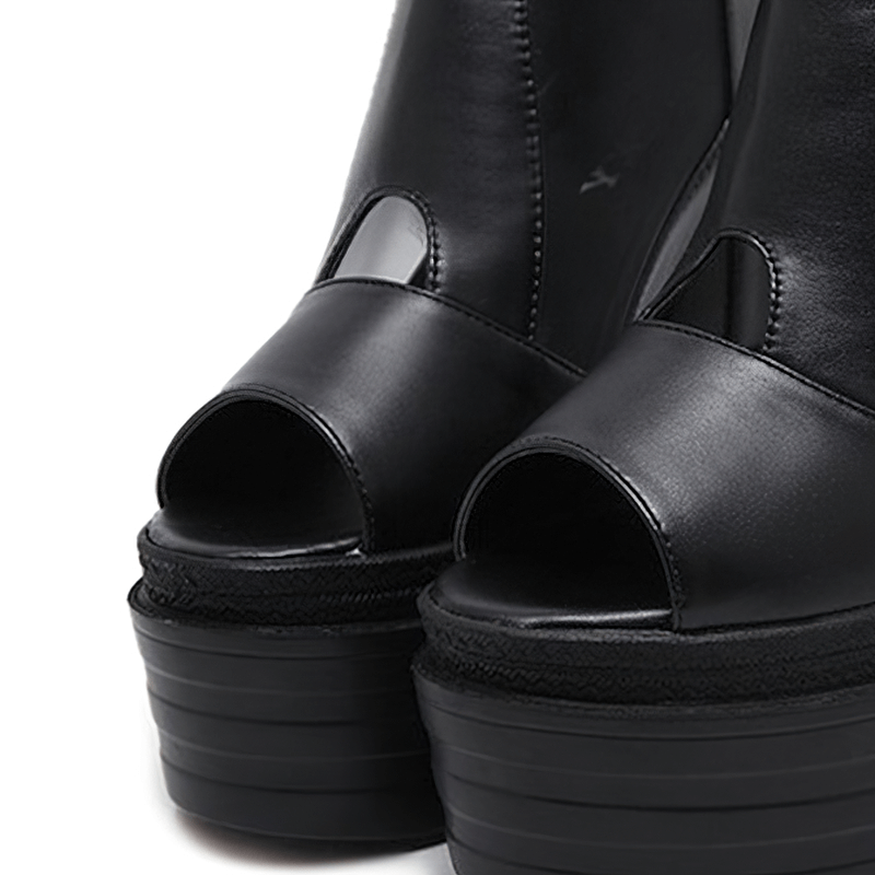 Close-up of women's open toe wedge sandals with black leather and stylish platform design.