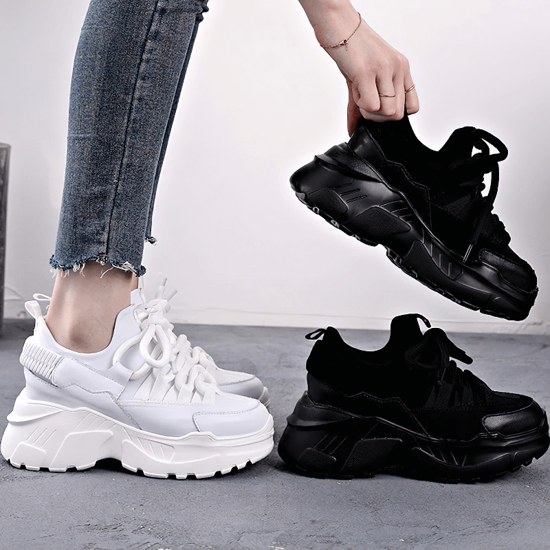 Women's platform sneakers in white and black, showcasing stylish casual lace-up design and elevated soles.