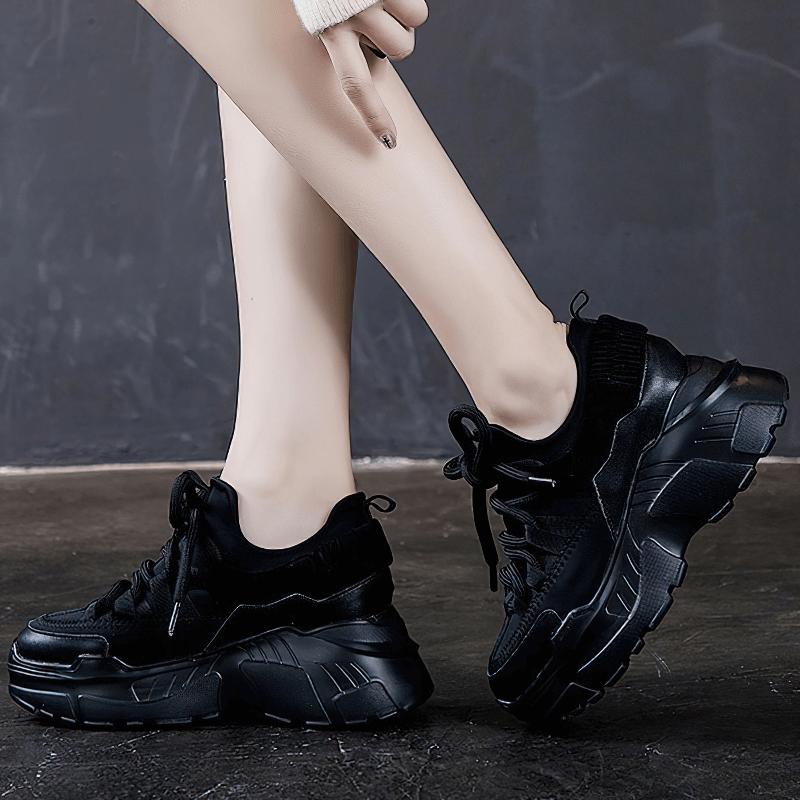 Stylish women's black platform sneakers with lace-up design and cushioned sole for casual outfits.
