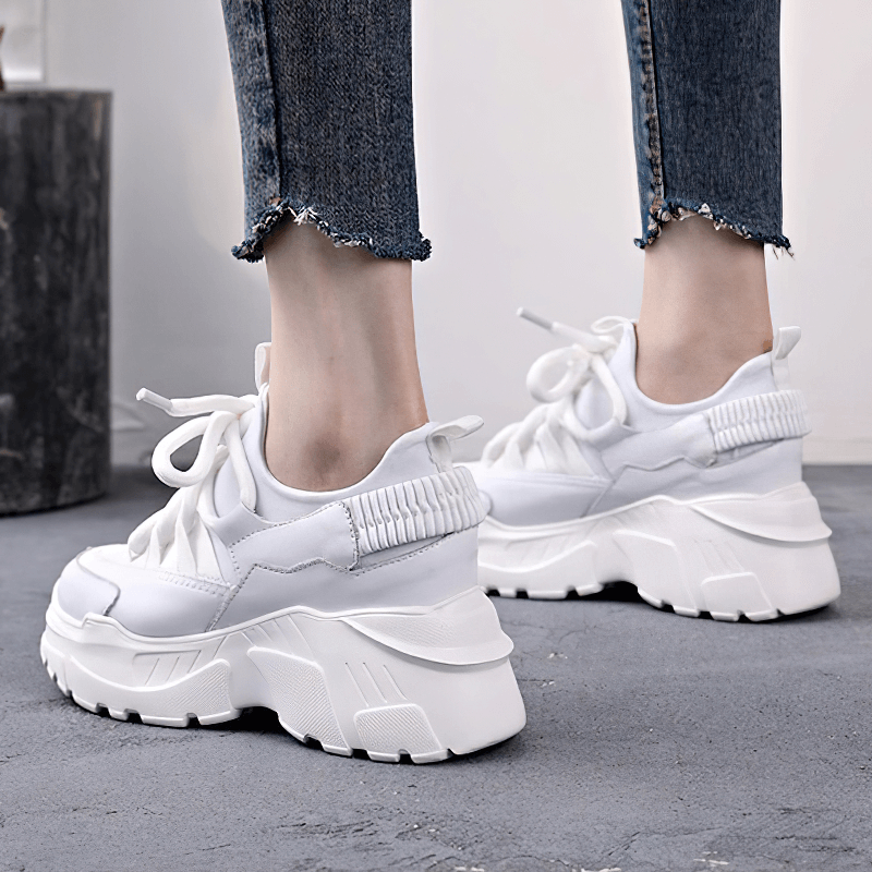 Stylish women's platform sneakers in white, featuring a chunky sole and lace-up design, perfect for casual outfits.