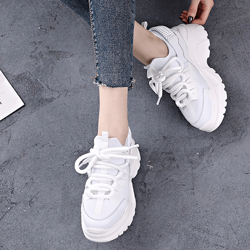 White women's platform sneakers with lace-up design, stylish look, and comfortable fit for casual outfits.