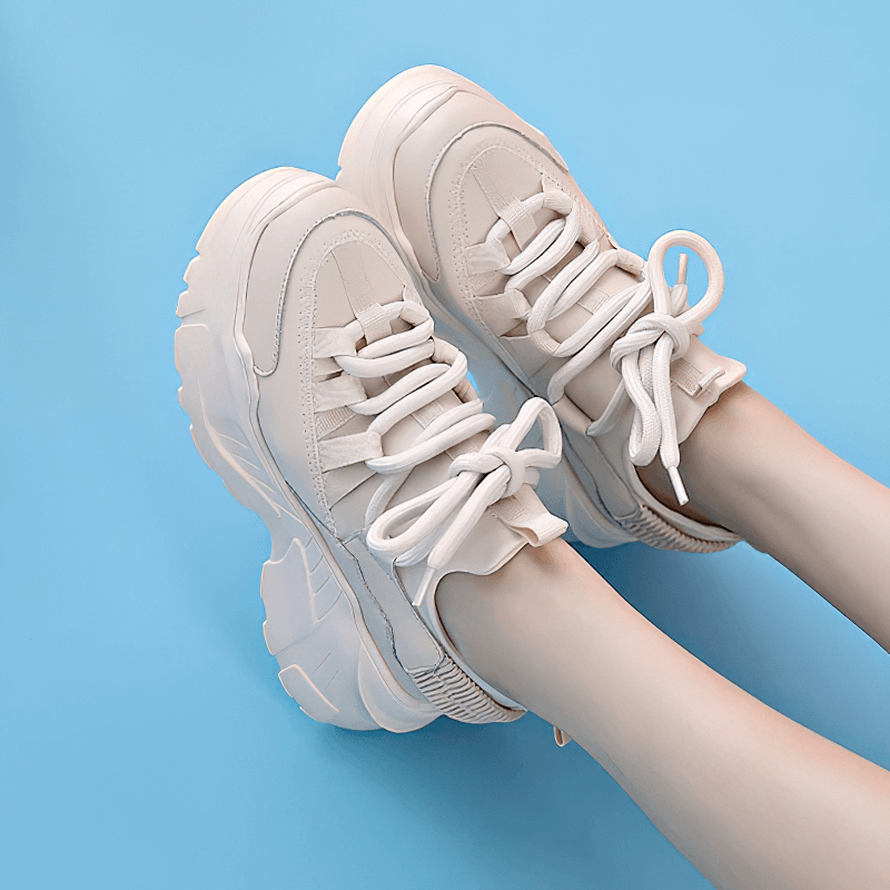 Stylish women’s genuine leather platform sneakers with lace-up design on a blue background.