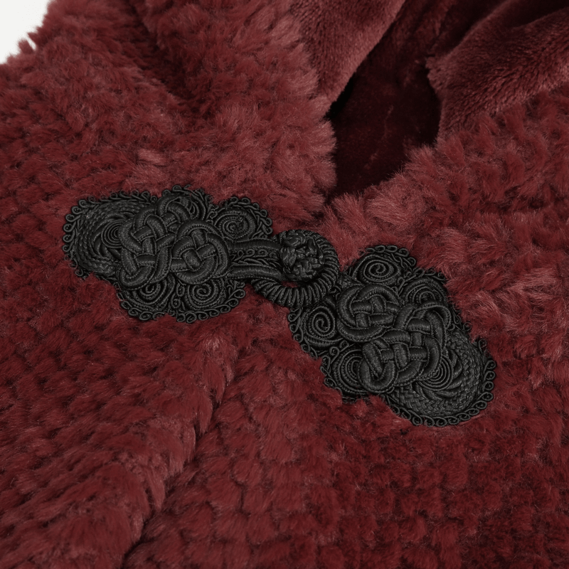 Close-up of luxurious burgundy fabric with intricate black embroidery on a women's hooded cape.