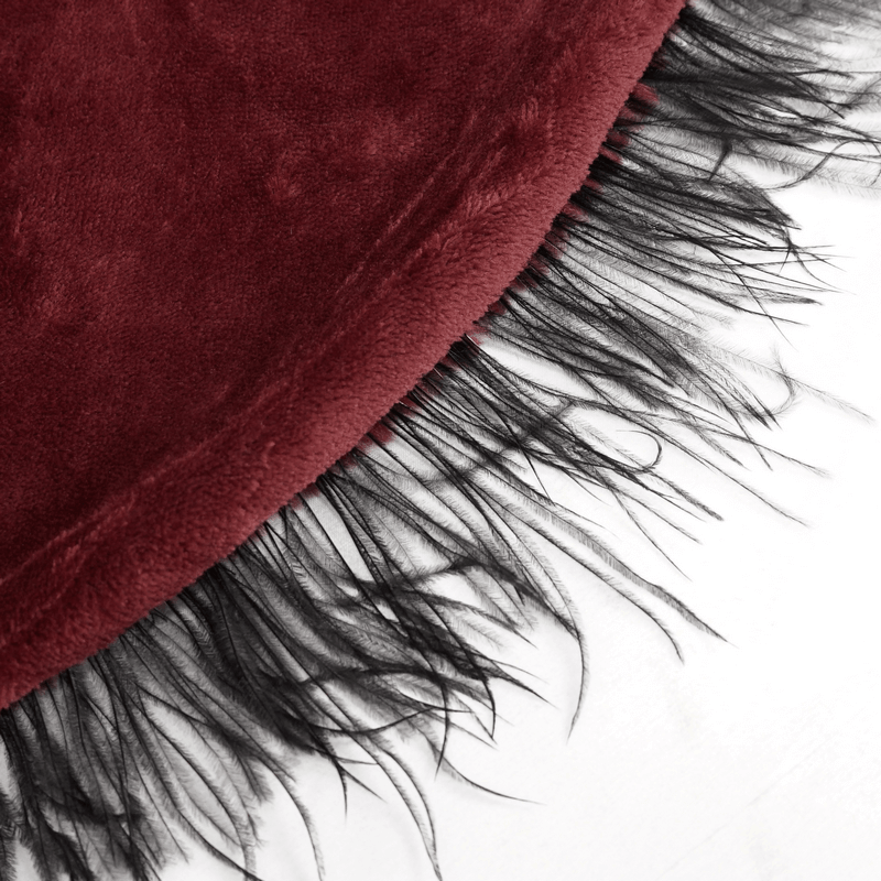 Close-up of the fringed hem of a women's red hooded cape, showcasing its plush texture and gothic style.