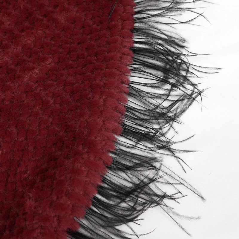 Close-up of the fringed edge of a red hooded cape showcasing its plush texture and distinctive black fringes.