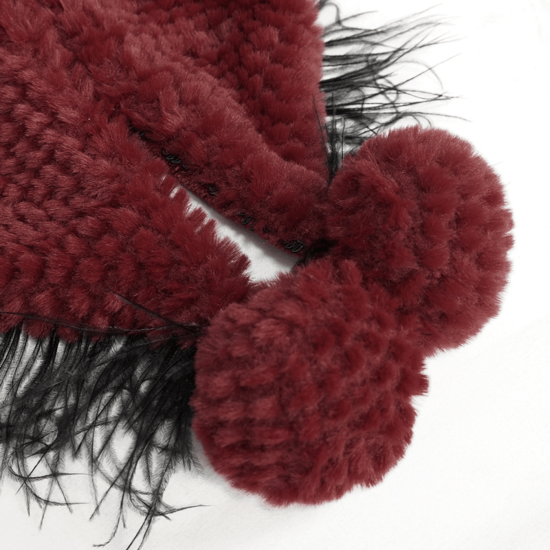 Close-up of women's red hooded cape with plush fur balls and fringes, showcasing gothic style elegance.