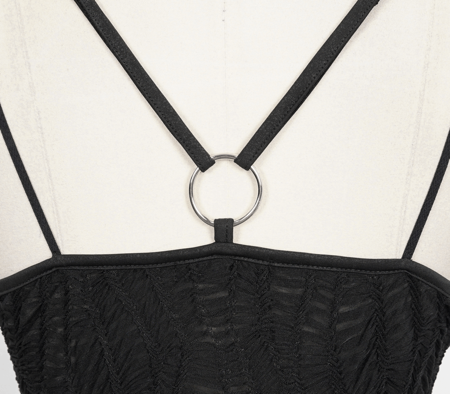Close-up of the back of a women's black short dress featuring cross straps and a chic silver ring detail.