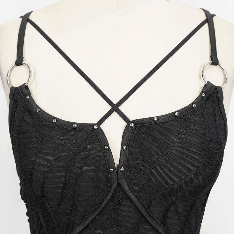 Close-up of a gothic punk black dress featuring cross straps and studded details, showcasing stylish textured fabric.