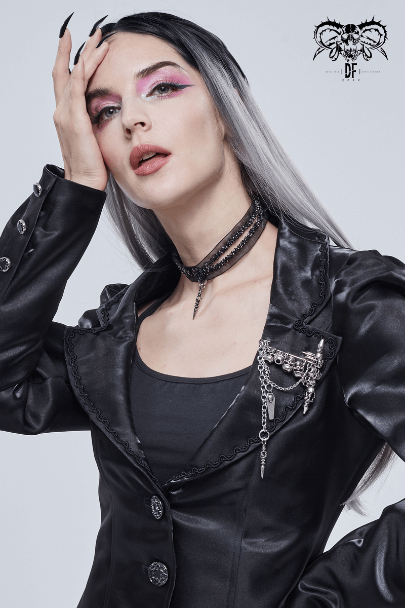 Stylish woman in a black gothic jacket with edgy makeup and accessories, showcasing a bold alternative look.