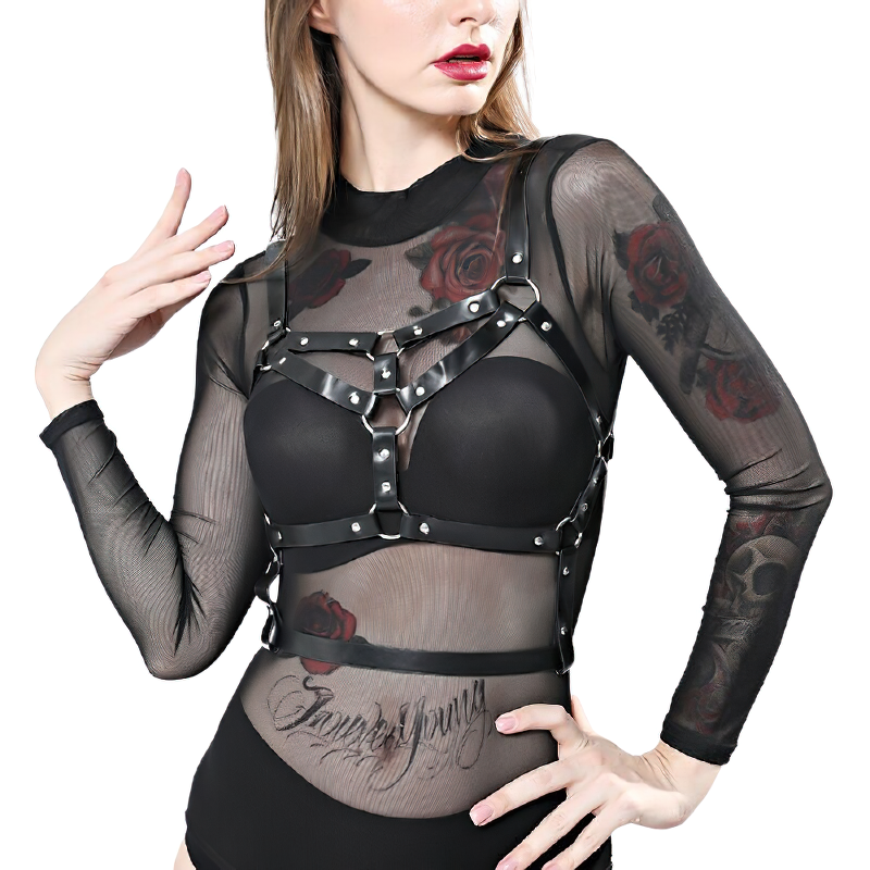 Woman wearing a gothic sexy body harness made of PU leather with silver fittings, over a sheer floral tattoo top.