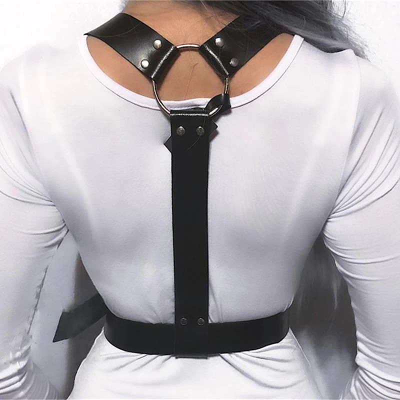 Stylish black faux leather body harness with adjustable buckles for goth fashion, cosplay, or roleplay lingerie on white dress.