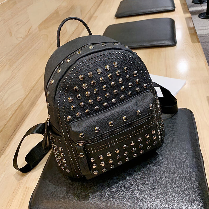 Stylish black backpack with rivets, perfect for casual and goth fashion, featuring zippered pockets for convenience.
