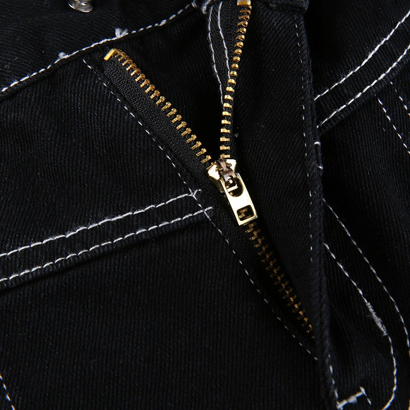 Close-up of a gold zipper detail on black high waist trousers, highlighting stylish goth fashion elements.