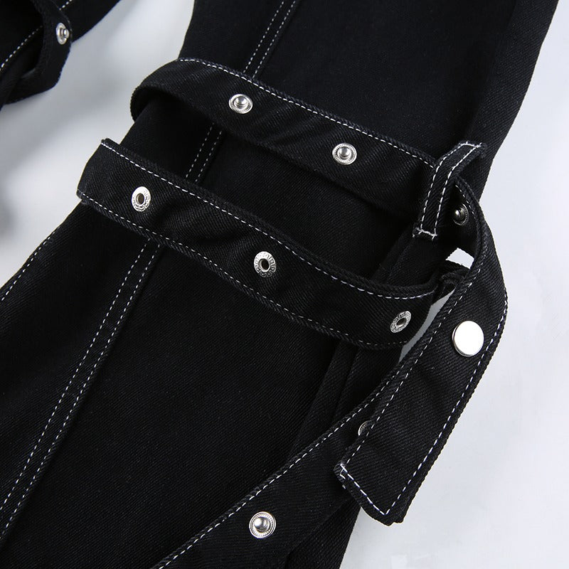 Close-up of black rivet trousers showcasing zip details and straps, ideal for women’s gothic and rave outfits.