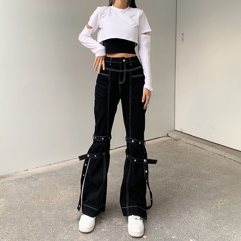 Trendy women in high waist black rivet trousers with zip details, stylish crop top, perfect for rock or goth outfits.