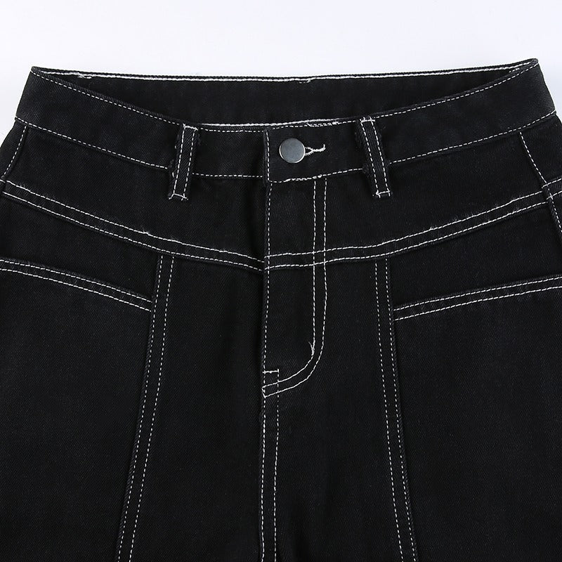 Close-up of women's high waist black trousers with stylish stitching and button detail, perfect for goth and rave outfits.