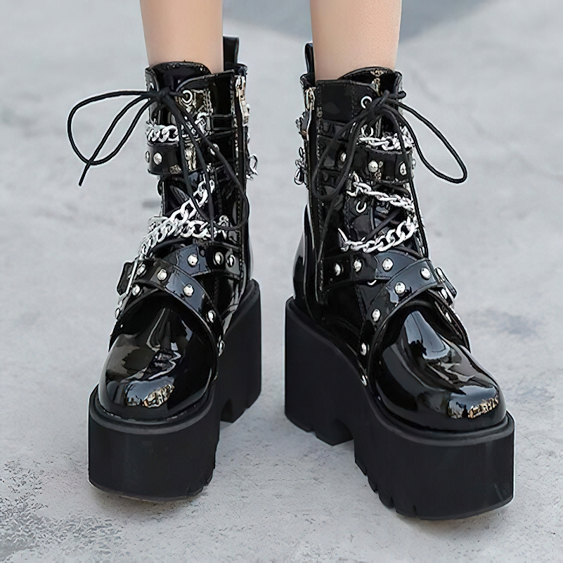 Stylish black women's boots with chains and rivets, featuring a chunky platform sole and lace-up design.