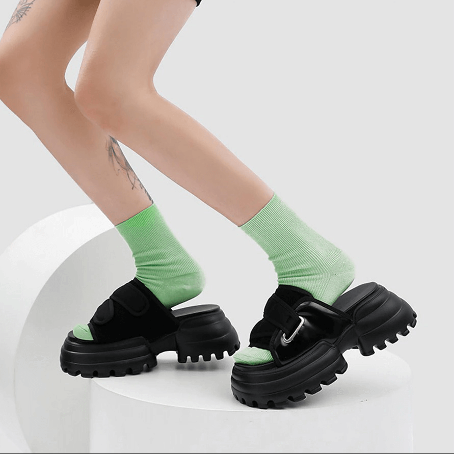 Stylish women's thick platform summer slippers, black mules with green socks, perfect for beach or poolside lounging.