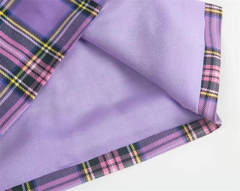 Close-up of purple plaid fabric with pink and black accents, showcasing the stylish design of a women's pencil skirt.
