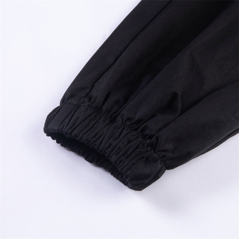 Close-up of elastic cuff on solid black women’s streetwear pants, showcasing gothic fashion style.