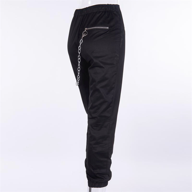 Solid black women’s streetwear pants with chain detail and zippered pockets for a cool gothic fashion look.
