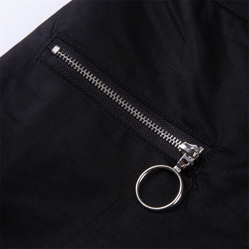 Close-up of zipper pocket detail on solid black gothic streetwear pants featuring chain embellishment.