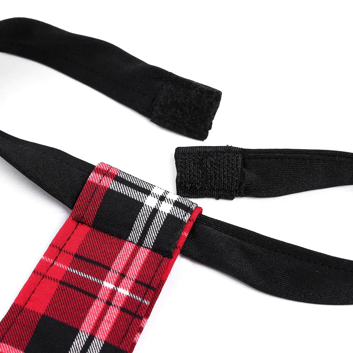 Close-up of the plaid tie and black straps from a sexy schoolgirl cosplay costume for adults.