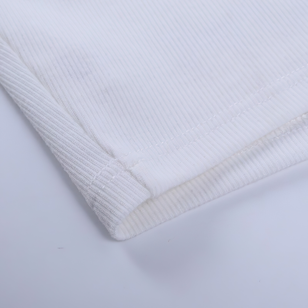 Close-up of the hem of a white ribbed crop top, showcasing quality stitching and fabric texture.