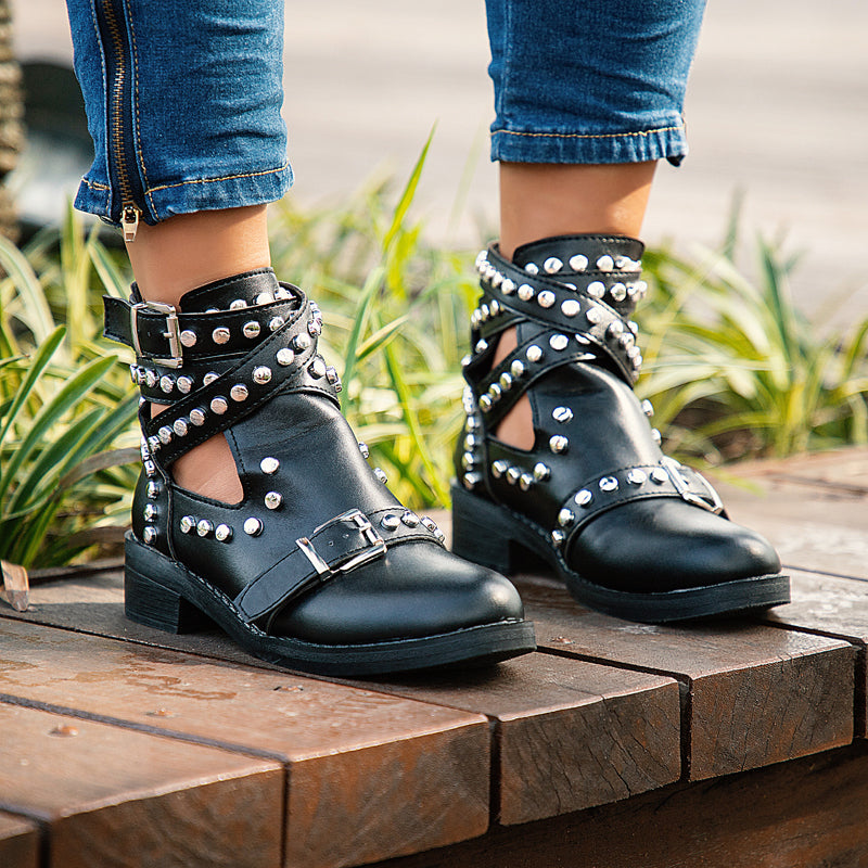 Stylish women's black ankle boots with rivets and buckles, perfect for a rock-inspired look.