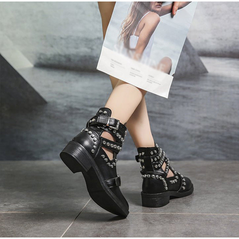 Stylish women's black ankle boots with rivets and buckle straps, perfect for a rock-inspired fashion statement.