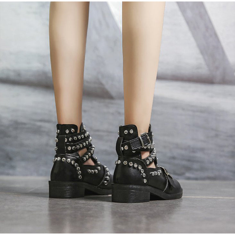 Stylish women's black ankle boots with rivets and buckle straps, perfect for a fashionable rock look.