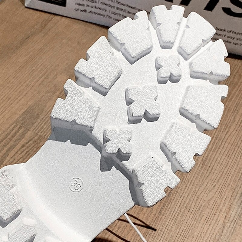 Sole of white ankle boot showing rugged tread pattern ideal for casual wear.