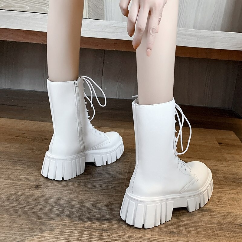 Stylish white women's ankle boots with lace-up design and chunky platform sole, perfect for casual outfits.