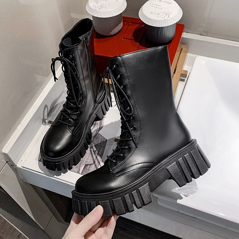 Stylish women's black ankle boots with lace-up design and chunky platform for a trendy casual look.